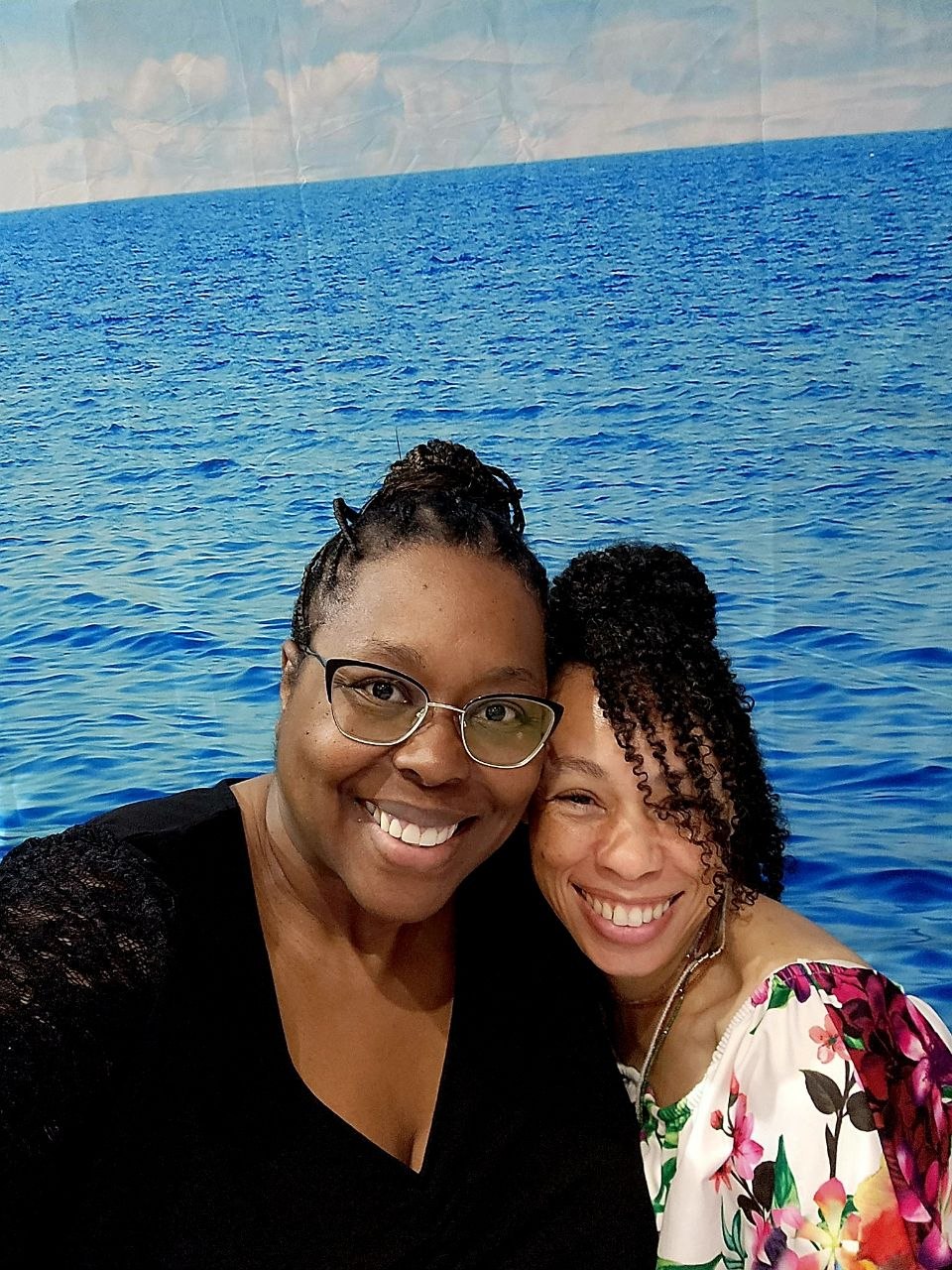 Candi smiling with a client before an ocean backdrop